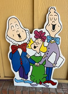 a wooden cutout of three people standing next to each other on the front door