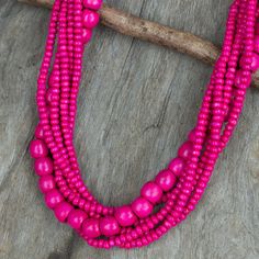 Thai artisan Sumalee Nawakul brings us this handcrafted wood necklace in hot pink. The long necklace features six strands of colorful wood beads; five strands with small beads and one strand with larger beads. The necklace closes with a wood toggle in the same luscious shade. Tropical Dance, Hot Pink Necklace, Hand Knotted Jewelry, Diy Tassel Necklace, Necklaces Pink, Pink Bead Necklace, Necklaces Long, Multicolor Necklace, Dance Necklace