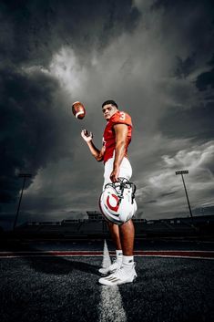 a man holding a football in his right hand and wearing white shorts on the other side