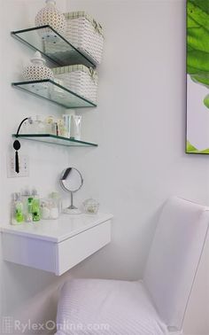 a white chair sitting in front of a desk with shelves on the wall above it