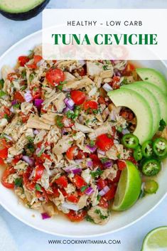 a white bowl filled with tuna ceviche next to sliced avocado and limes