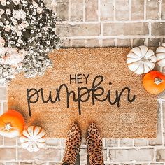 someone is standing in front of a door mat that says hey pumpkin