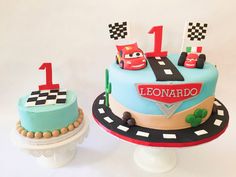 two birthday cakes with cars on them sitting on top of each other