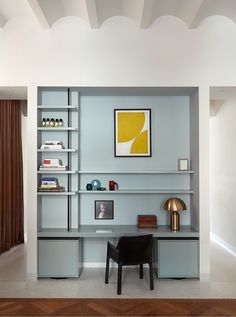 a modern home office with built - in shelving units and shelves, along with a painting on the wall