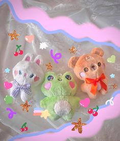 three small stuffed animals sitting on top of a white cloth covered table with hearts and stars