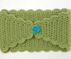 a green crocheted headband with a blue flower