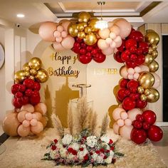 a birthday arch with balloons and flowers in front of the entrance to a party room