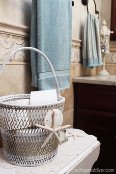 a basket sitting on top of a sink next to a towel rack