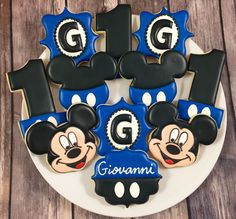 mickey mouse cookies on a plate with the number one and two for grouamm