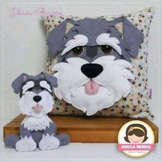 a stuffed dog sitting next to a pillow on top of a wooden shelf with a cushion behind it