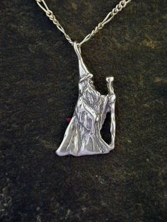 This Wizard Sorcerer Magician pendant is Sterling Silver. The included chain is a Sterling Silver Figaro 50 chain. You may choose 16, 18 or 20 inch at the same price. Other length available at sightly higher prices. This Wizard Sorcerer Magician pendant measures I hand cast all my pieces using the lost wax casting method. Please ask your needs. You may call me with questions, often I am out so please use my machine. 831-476-3176. Satisfaction Guaranteed!I send items USPS First Class unless other Silver Pendant Necklace For Fantasy Events, Spiritual Pendant Necklaces For Fantasy Events, Spiritual Pendant Necklace For Fantasy Events, Magical Silver Charm Necklaces For Gift, Sterling Silver Fantasy Necklace For Gift, Silver Fantasy Necklace With Hand Cast, Mystical Sterling Silver Pendant Necklace, Hand-cast Fantasy Pendant Jewelry, Wizard Necklace