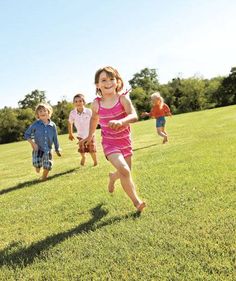 children running in the grass on a sunny day