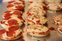 pepperoni mini pizzas on a baking sheet ready to be baked