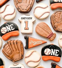 decorated cookies with baseball, mitts and gloves are arranged on a white tablecloth