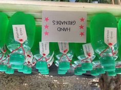 green liquid bottles with labels on them are sitting on a table in front of trees