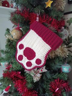 a crocheted stocking hanging from a christmas tree with red and white decorations