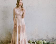 a woman standing in front of a wall wearing a dress