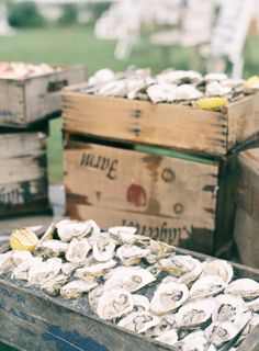 several wooden boxes filled with oysters sitting on top of a table