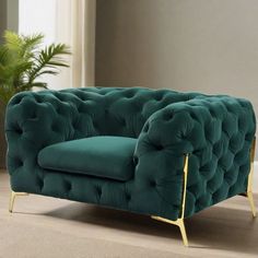 a green chair sitting on top of a wooden floor next to a potted plant