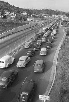 an old black and white photo of traffic on the freeway