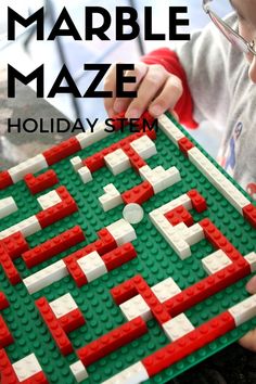 a child is playing with a lego marble maze