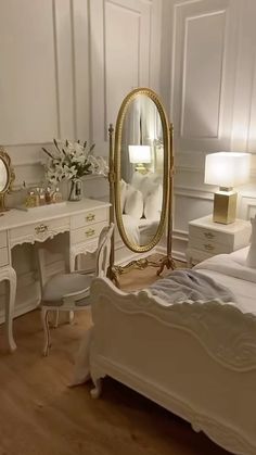 a bedroom with white furniture and gold accents on the walls, along with a large mirror