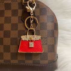 a brown and red purse with a keychain hanging from it's side