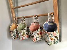 four purses are hanging on a wooden rack