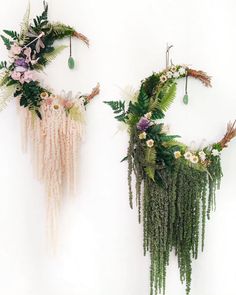 two wall hangings made out of plants and flowers on the side of a white wall