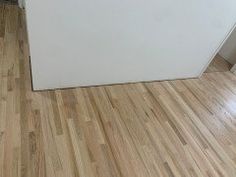 a white refrigerator freezer sitting on top of a hard wood floor