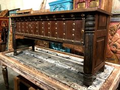 an old wooden chest sitting on top of a table next to other antique furniture and decor