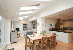 a kitchen and dining room with skylights in the ceiling is very open to the living area