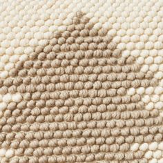 the texture of an area rug with white and beige colors is shown in this close up photo