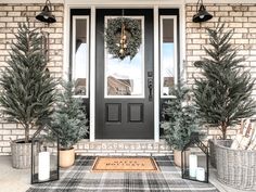 two potted plants are sitting on the front porch next to a black and white door