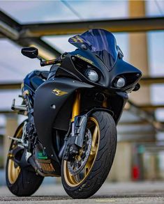 a black and gold motorcycle parked in front of a building