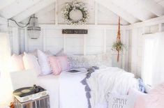 a bedroom with white walls and wooden ceilings, decorated in pink and white colors is shown