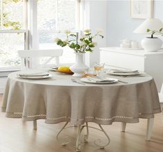 a dining table with plates and silverware on it in front of a large window