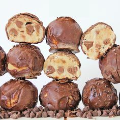 chocolate covered doughnuts stacked on top of each other in front of white background