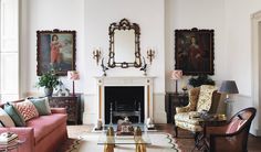 a living room filled with furniture and a fire place under a mirror on the wall