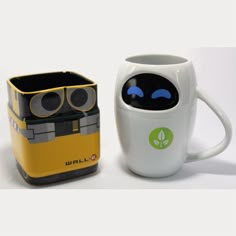 two coffee mugs one with eyes and the other with an image of a robot