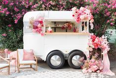 a food truck decorated with pink flowers and greenery