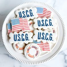 decorated cookies in the shape of usa and us c g on a white platter