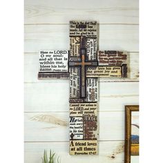 a cross made out of wood with words on it and a potted plant next to it