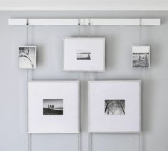 four frames hanging on a wall with chains attached to them and pictures hung up against the wall