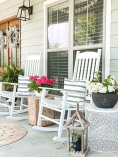 white rocking chairs on the front porch with potted plants and flowers in vases