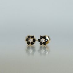 Dainty flower shaped stud earrings. Perfect for pairing with multiple piercings. Available in Black or Black with White CZ Stone DETAILS * Thick plating of 14k Gold or Rhodium over 925 Sterling Silver * Sold as a Pair * Hypoallergenic and nickel-free * 5 mm x 5 mm * Also available in white cz, ruby, sapphire or emerald Huggies on Model: https://www.etsy.com/listing/708078947/sapphire-huggie-earrings-gold-cz-huggies?ga_search_query=black%2Bhuggies&ref=shop_items_search_1&pro=1 Made with 1 Black Crystal Earrings Studs, Black Stone Gold Earrings, Black Bead Earrings Gold, Black Stone Earrings Gold, Black Earrings Studs, Black Beads Earrings, Gold Earrings For Kids, Small Earrings Gold, Black Jewellery