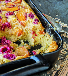 a close up of a cake in a pan with fruit toppings on the side