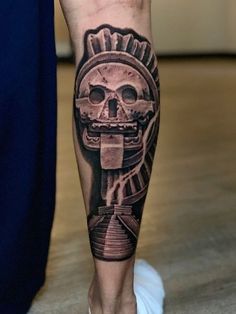 a man's leg with a tattoo on it and a skull in the middle