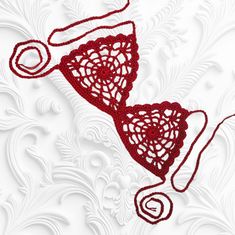 a red lace bralet on a white background with swirls and circles around it