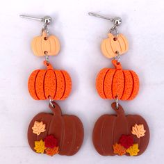 the earrings are decorated with pumpkins and leaves